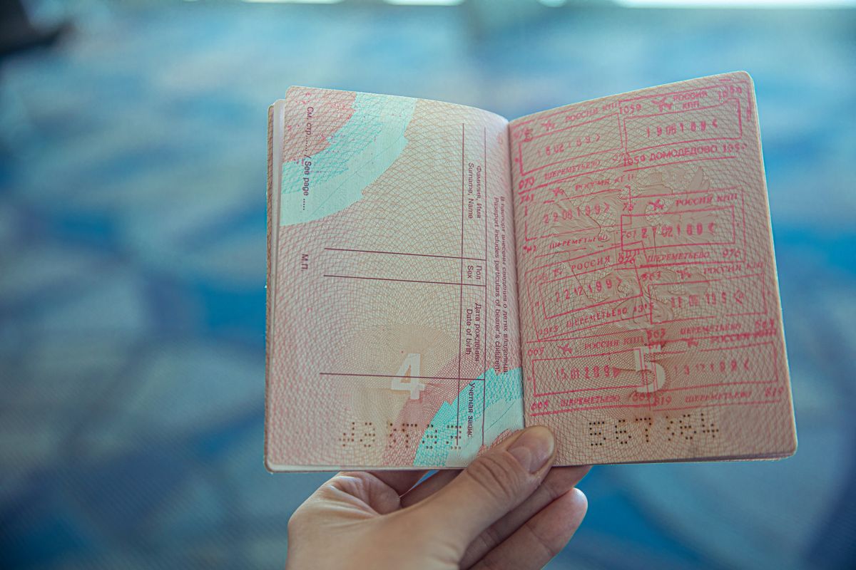 Traveler holding an open passport with visa stamps