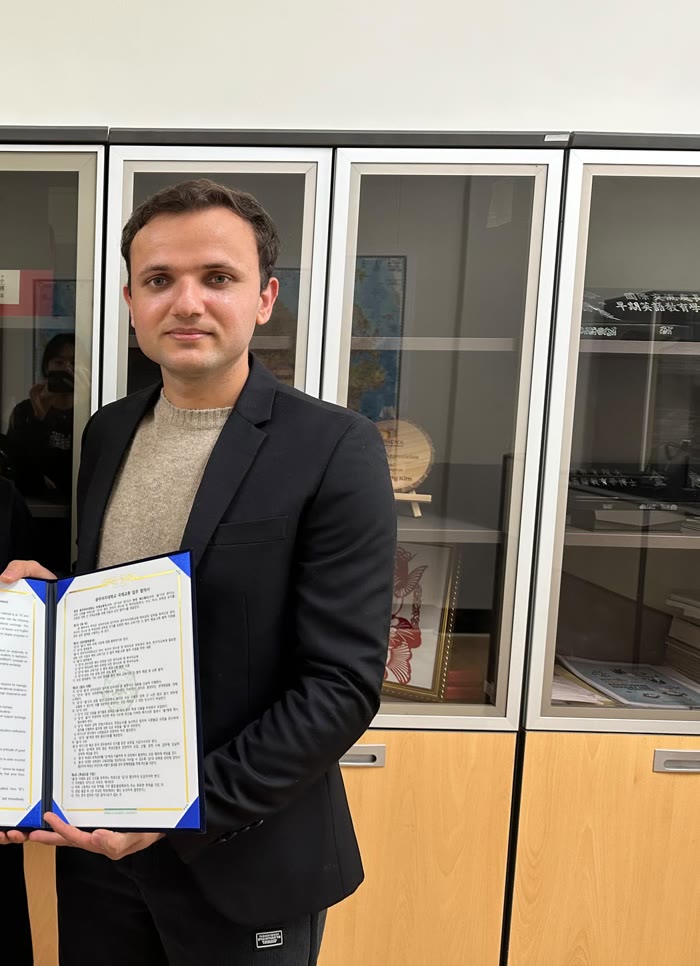 Babar Ali Khan holding a signed university cooperation agreement